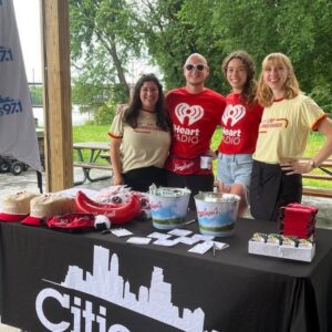 Photo of 4 people smiling at the camera with I heart radio shirts on
