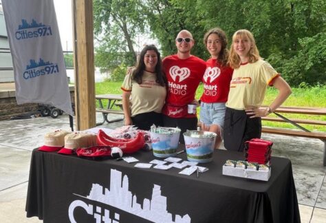 Photo of 4 people smiling at the camera with I heart radio shirts on